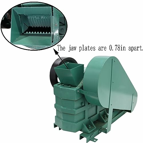 Green industrial jaw crusher with close-up of jaw plates.